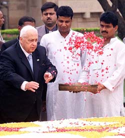 Israeli Prime Minister Ariel Sharon scatters flower petals on the Mahatma Gandhi memorial at Rajghat in New Delhi 