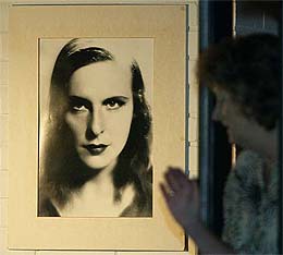 Gisela Jahn, secretary of former German artist and photographer Leni Riefenstahl, walks past a photo of Riefenstahl in her house in Poecking