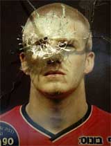 The window in front of a poster of English soccer star David Beckham is pictured after being broken by shrapnel near to the scene of a suicide bombing attack in Jerusalem 