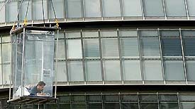 US illusionist David Blaine writes in his notebook as he hangs in a glass box next to Greater London Authority headquarters near Tower Bridge in London 