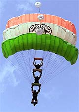 Indian Air Force skydivers using parachutes in the colours of the Indian flag perform on the second day of a two-day arms exhibition in Ahmedabad