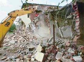 A JCB razes illegal structures at Dadu Majra Colony in Chandigarh on Wednesday