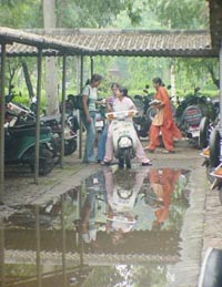 A puddle in front of the parking lot of the Government College for Women