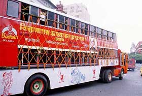 A double decker trolley bus, converted to a mobile book library, moves on the streets of Kolkata 