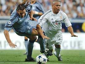 Real Madrids Brazilian striker Ronaldo is tackled by Marseilles Daniel Van Buyten 