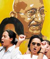 Activists of pro-democracy Burmese group demonstrate in front of a portrait of Mahatma Gandhi in New Delhi 
