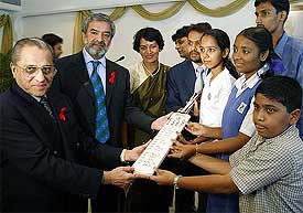 Indian cricket board President Jagmohan Dalmiya and ICC President Ehsan Mani hold a cricket bat with a group of children