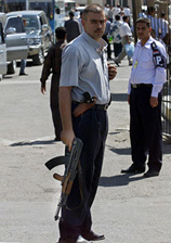 Policemen stand guard at the entrance of Yarmouk Hospital in Baghdad, where Akila al-Hashemi, a member of Iraqs 25-member Governing Council, was admitted