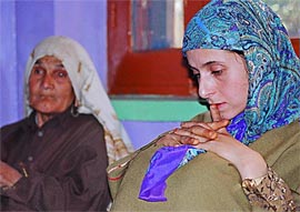 Grief-stricken Afroza wife of Tahir Hussan Maqdoomi, along with a relative at Tujjar Sharif village 