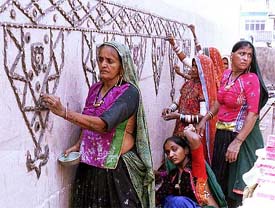 Tribal artists from Bhuj decorate a pandal for the forthcoming Durga Puja festival with their traditional mud-mirror work, in Kolkata 