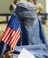 A burkha clad Afghan woman holds a US flag at a ceremony in Kabul 