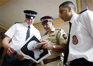 ndian police officer N. S. Talavlikar checks crime case papers displayed by British police investigation officials