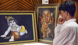 A boy looks at Anchal Jain's works, done with needle and thread, in Ambala
