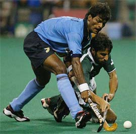 India's Dhanraj Pilay fights for the ball with Pakistan's Shakeel Abassi 