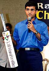Indian cricket captain Saurav Ganguly holds a cricket bat signed by other Indian cricketers 