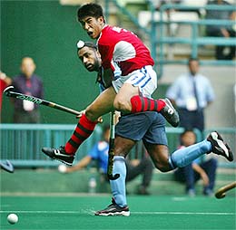 South Korea's Kim Chul (R) jumps as India's Baljit Dhillon hits the ball during their Asia Cup semifinal match in Kuala Lumpur on Friday.