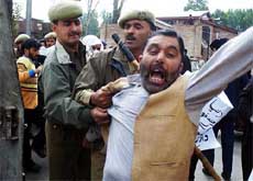 Policemen restrain an activist of the breakaway faction of the Hurriyat Conference