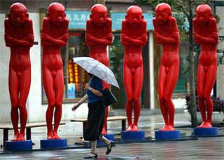 A woman looks at statues on display along a main shopping street in Beijing 