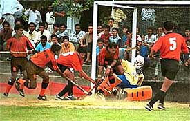 ONGCs Anurag Raghuvanshi makes an attempt to retrieve the ball as team-mate S.H.V. Mishra (No. 5) looks on in the last quarter-final 