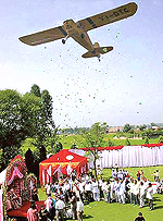 An aircraft showers colourful buntings on the wedding dais. 
