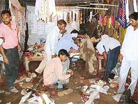 People clear the debris after a fire broke out in two kiosks at the Mansa Devi Shrine Complex in Panchkula on Monday evening.