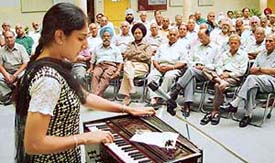 A girl from the Dev Samaj College of Education sings at the International Day of Older Persons celebrations 