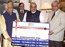 Prime Minister Atal Bihari Vajpayee receives a dividend cheque of Rs 3,598 crore from Union Petroleum Minister Ram Naik and Chief Managing Director of ONGC Subir Raha in New Delhi on Friday.