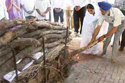 Mr Shamsher Singh and Mrs Gursharan Kaur jointly light the funeral pyre of their father, Hari Singh, at the SAS Nagar cremation grounds on Sunday.