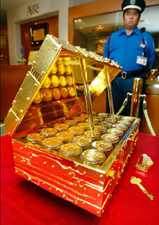 A pure gold traditional chest, filled with gold coins, is on display
