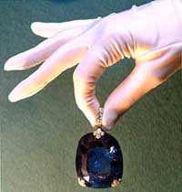 An employee of the Christie's auction house holds an historic 478 carat sapphire previously owned by Queen Marie of Romania