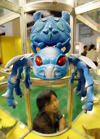 A Chinese exhibitor prepares under an eight-legged remote controlled toy