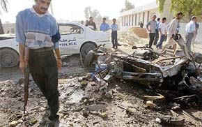 An Iraqi policeman walks through the blast area