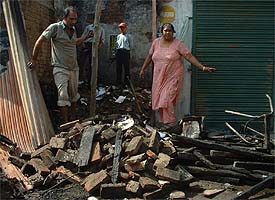The owner of the shop inspects her shop that was destroyed in a gas cylinder blast