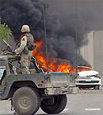 A US soldier guards the area outside a central Baghdad hotel where a powerful car bomb killed at least 6 persons