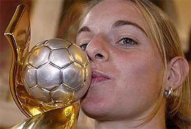 Scorer of the golden goal, Nia Kuenzer of Germany, kisses the women's World Cup trophy at a reception party in Frankfurt 