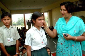 Chairperson of Hospital Welfare Section Mrs Sunil Aggarwal presents a hearing aid equipment to a deaf and dumb student of Mahant Gurbanta School at Bathinda 