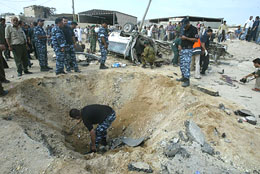Palestinian policemen search the scene after a blast by an apparent roadside bomb in the Gaza Strip