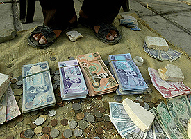 A man sells old Iraqi Dinars with Saddam Hussein's picture as war souvenirs on a side walk in Amman