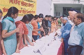 Students of Master Tara Singh College examine adulterated food items at an exhibition organised to mark World Food Day in Ludhiana