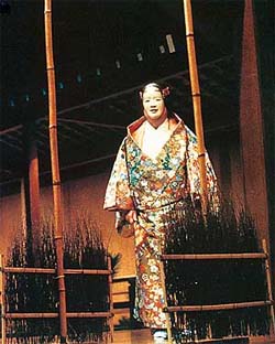 A Noh actor on stage, wearing a wide-sleeved kimono. From the exhibition, "Sculpture in Silk"