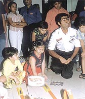 Formula driver Karun Chandhok plays with kids on the hot wheel track of a departmental store in Delhi