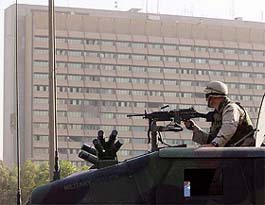 A US Army soldier patrols past Baghdads Al Rashid hotel after a series of explosions rocked the building
