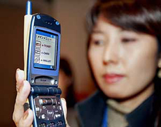An NTT DoCoMo employee displays prototype model of the new mobile handset SO504iC, equipped with Sonys contact less IC card technology FeliCa, at a Press preview in Tokyo 