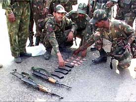 Army personnel display weapons recovered from militants after a gun-battle at Akhnoor 
