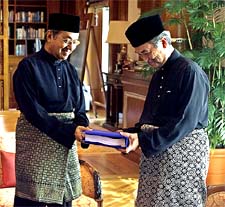 Outgoing Malaysian Prime Minister Mahathir Mohammad hands over the Prime Ministers personal files to his successor Abdullah Ahmed Badawi in Putrajaya 