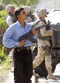 An Iraqi policeman looks up for intruders suspected of looting