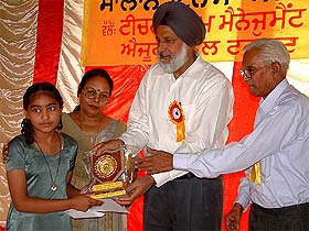 Dr Kehar Singh, Chairman, Punjab School Education Board, gives away a certificate to a ward of a government schoolteacher for getting good marks in board exams