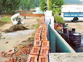 The boundary wall that was constructed at the gate of Titan Motors