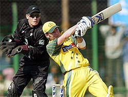 Australia's Michael Clarke hits a shot as New Zealand wicketkeeper Brendon McCullum looks on 