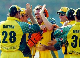 Australias Brad Williams celebrates with teammates after claiming the wicket of New Zealand's Craig McMillan 